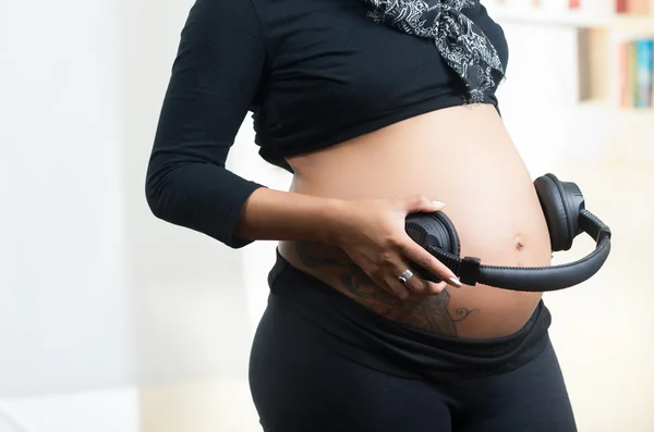 Mulheres grávidas barriga com fones de ouvido — Fotografia de Stock