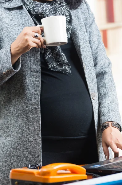 Mulher grávida vestindo roupas casuais no trabalho — Fotografia de Stock