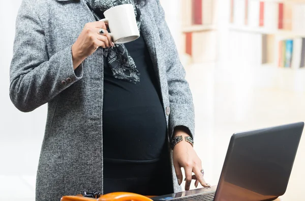 Pregnant woman wearing casual clothes at work — Stock Photo, Image