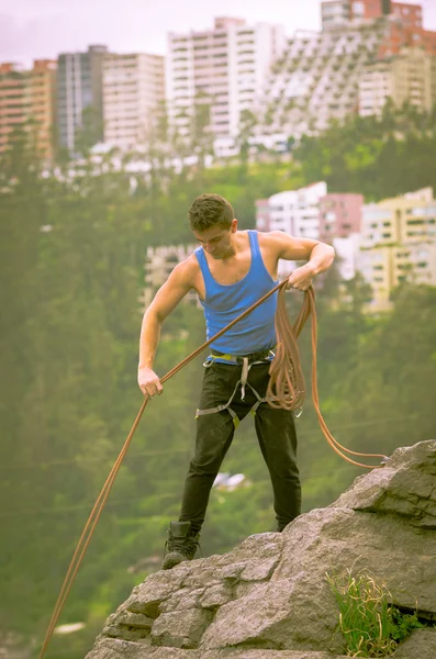 Athletic man standing on cliff with rope in hands — Stock Photo, Image