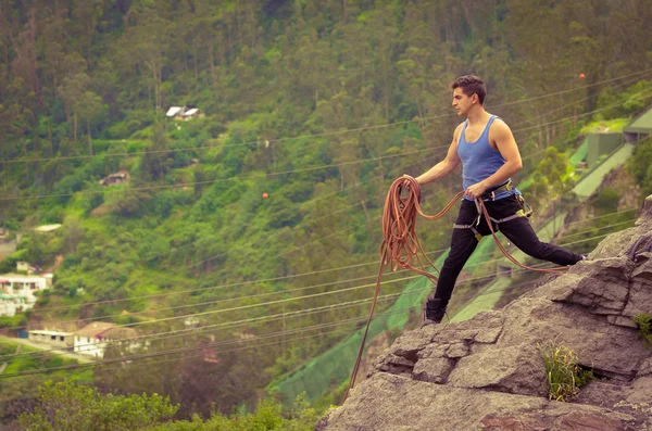 Hombre atlético de pie en el acantilado con la cuerda en las manos — Foto de Stock