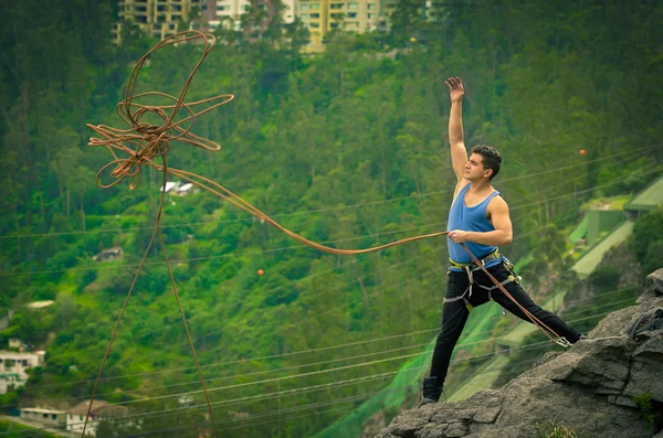 Спортсмен стоїть на скелі з мотузкою в руках — стокове фото