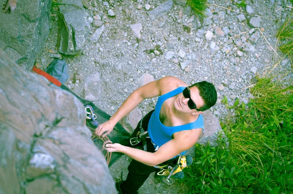 Homme escalade montagne avec lunettes de soleil — Photo