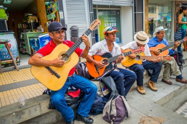 Unidentify indigenous men playing guitar in the commercial street plaza of Armenia, Colombia clipart