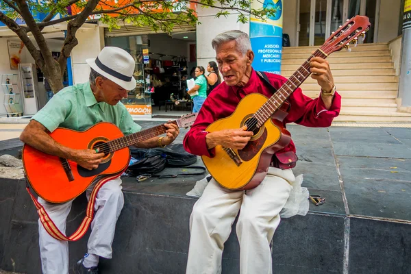 Two unidentify indigenous men playing guitar in the commercial street of Armenia, Colombia — Stock Photo, Image