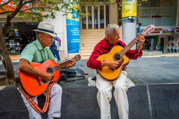 Due indigeni non identificati che suonano la chitarra nella strada commerciale di Armenia, Colombia — Foto Stock