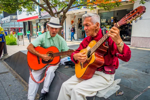 Два неизвестных коренных человека, играющих на гитаре на коммерческой улице Армении, Колумбия — стоковое фото