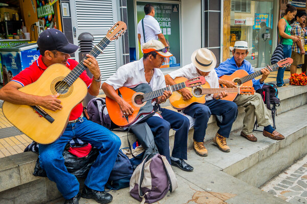 Unidentify indigenous men playing guitar in the commercial street plaza of Armenia, Colombia