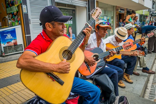Неопознанные коренные жители, играющие на гитаре на торговой площади Армении, Колумбии — стоковое фото