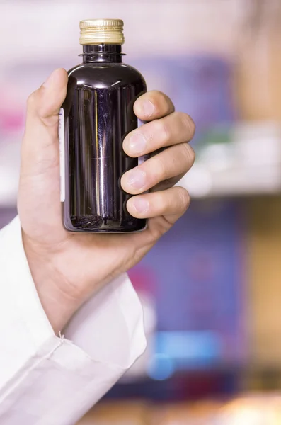 Farmacéutico mano sosteniendo botella — Foto de Stock