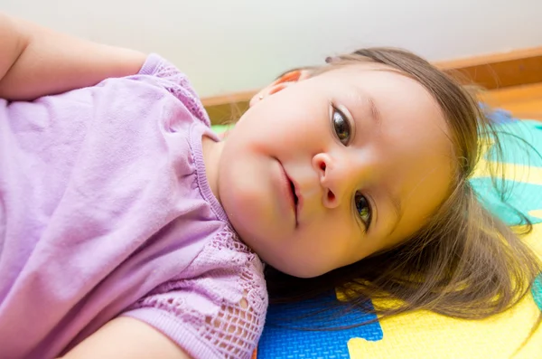 Entzückendes kleines Mädchen, das seitlich liegt — Stockfoto