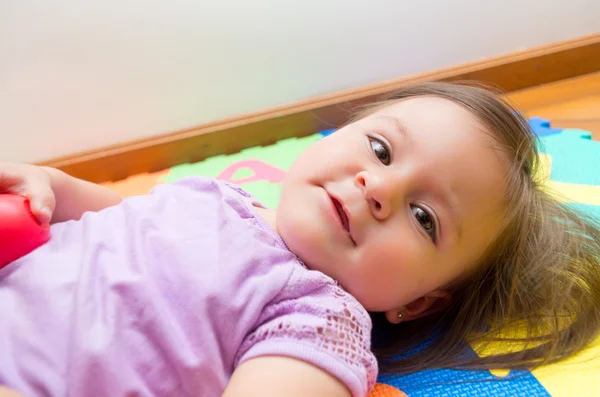 Closeup adorável bebê menina deitada no chão — Fotografia de Stock