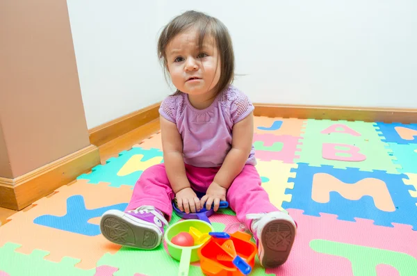 Adorável bebê menina jogando no chão tapetes — Fotografia de Stock