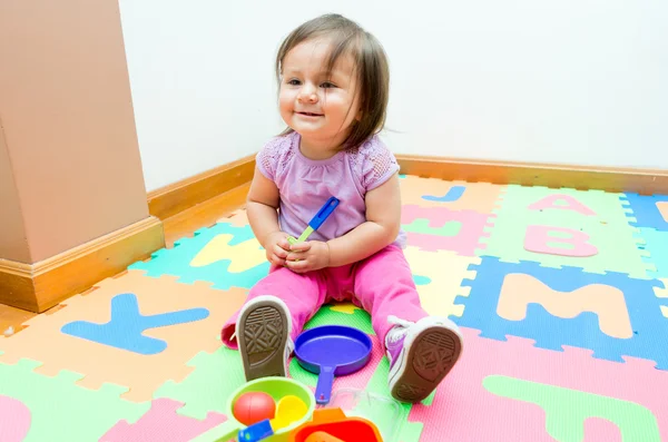 Adorável bebê menina jogando no chão tapetes — Fotografia de Stock