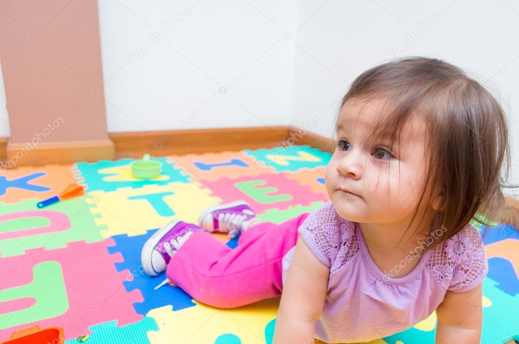 Adorable baby girl playing on floor
