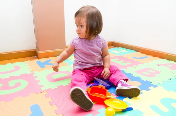 Förtjusande baby flicka som leker på golvet — Stockfoto