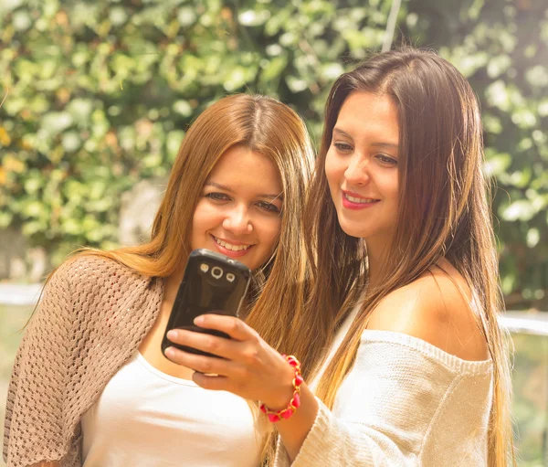 Meninas ao ar livre olhando para o telefone — Fotografia de Stock