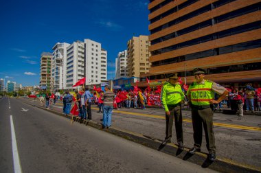 Two ecuadorian policemen supervising protesters marching in the capital city Quito against government of president Rafael Correa