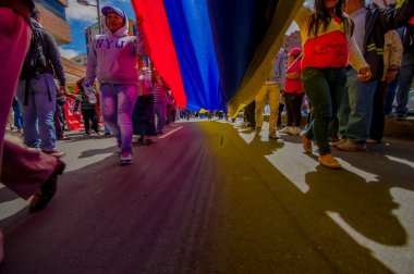 Street view from under giant ecuadorian flag during anti government march and protests in Quito