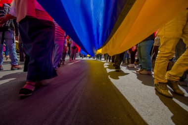 Street view from under giant ecuadorian flag during anti government march and protests in Quito