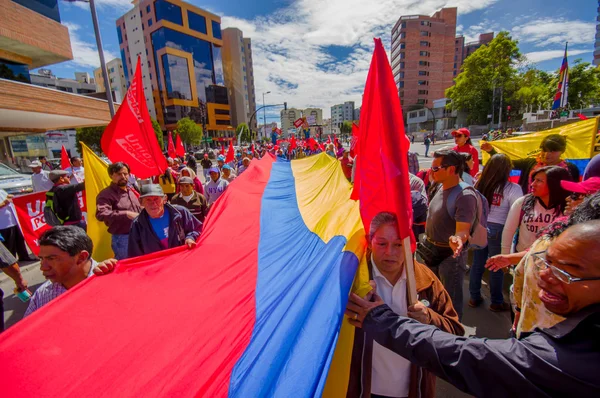 Protesters holding giant flag marching with ecuadorian and Union Popular flags in the capital city Quito against government of president Rafael Correa — Stok fotoğraf