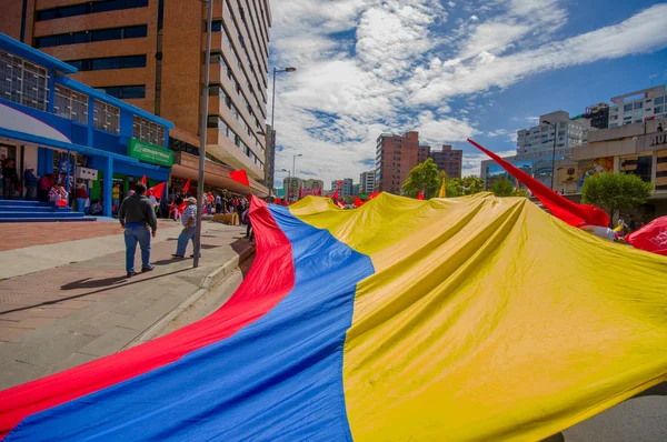 Manifestantes portando bandera gigante marchando con banderas ecuatorianas y Union Popular en la capital Quito contra gobierno del presidente Rafael Correa — Foto de Stock