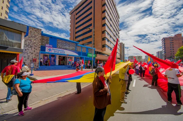 Protesters holding giant flag marching with ecuadorian and Union Popular flags in the capital city Quito against government of president Rafael Correa — Stok fotoğraf
