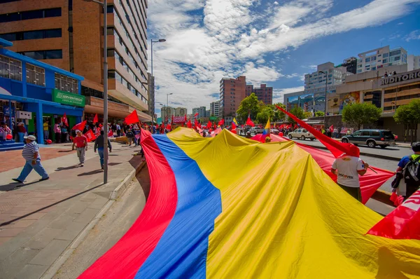 Bandera ecuatoriana muy grande siendo transportada por las calles de la ciudad como parte del partido Unión Popular marchando en la capital Quito contra el actual gobierno incluyendo al presidente Rafael Correa — Foto de Stock