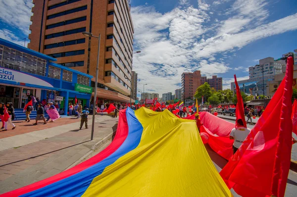 Bandera ecuatoriana muy grande siendo transportada por las calles de la ciudad como parte del partido Unión Popular marchando en la capital Quito contra el actual gobierno incluyendo al presidente Rafael Correa — Foto de Stock