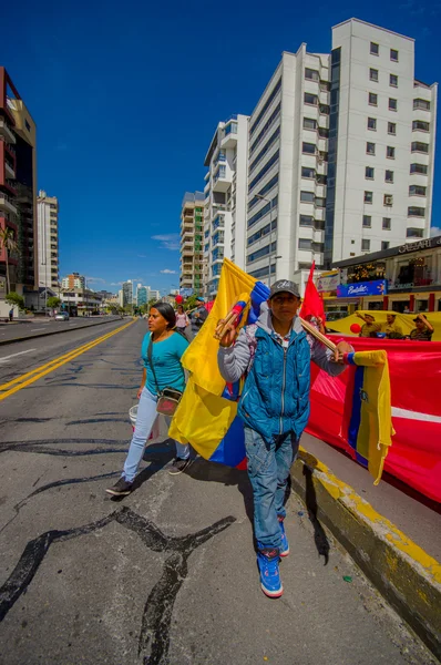 Vendedor de bandera ecuatoriana caminando por la soleada calle de la ciudad con varios tamaños en venta — Foto de Stock