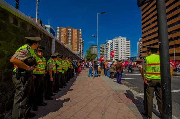 Long line of ecuadorian policemen supervising protesters from the party Unidad Popular marching in capital city Quito against government president Rafael Correa — Zdjęcie stockowe