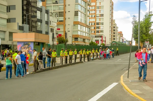 Schlange von Polizisten, die den öffentlichen Eingang zur Quito-Straße blockieren, und Menschen, die auf die Ankunft der Autokolonne Papst Francis warten, während die Südamerika-Tour beginnt — Stockfoto