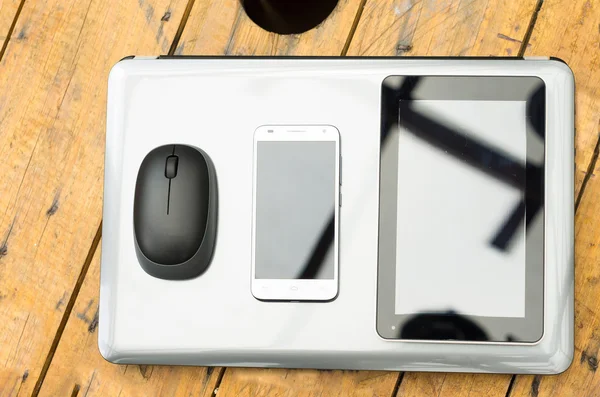 Ordenador portátil de color plata con el ratón, móvil y tableta en la parte superior desde el ángulo superior fondo de madera —  Fotos de Stock