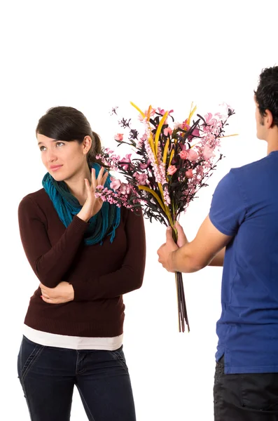 L'homme essaie de donner des fleurs à sa petite amie, mais elle le tamise en lui tenant la main et en regardant contrarié — Photo