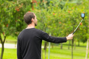 İspanyol adam yan profil açıdan ateş park ortamda selfie sopa ile poz