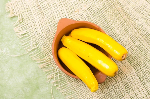 Zucchinis frescos de colores brillantes en terracota cuenco de cáñamo un paño — Foto de Stock