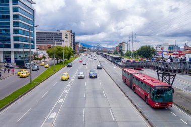 Great overview shot of main road portraing red public transportation Transmilenio, background brick urban buildings from Bogota Colombia clipart