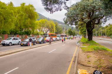 Kimliği belirsiz İspanyol bisikletçiler araç ücretsiz street ters şeritte ağaçlar Candelaria alan Bogota, Kolombiya tarafından bölünmüş yoğun trafik ile hareket