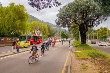 Kimliği belirsiz İspanyol bisikletçiler araç ücretsiz street ters şeritte ağaçlar Candelaria alan Bogota, Kolombiya tarafından bölünmüş yoğun trafik ile hareket