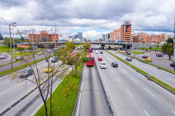 ภาพรวมที่ยอดเยี่ยมของถนนสายหลักที่แสดงถึงการขนส่งสาธารณะสีแดง Transmilenio อาคารพื้นหลังอิฐในเมืองจากโบโกตาโคลัมเบีย — ภาพถ่ายสต็อก