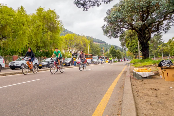 Niezidentyfikowane hiszpanin rowerzystów poruszanie pojazdu wolna ulicy o dużym natężeniu ruchu w przeciwnym pasie podzielona przez drzewa dzielnicy Candelaria Bogota, Kolumbia — Zdjęcie stockowe