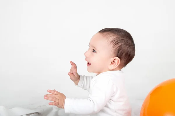 Niedliches Baby spielt und lächelt mit erhobenen Händen — Stockfoto