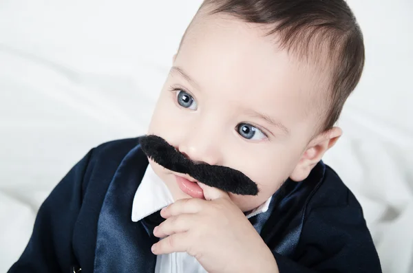 Söt vacker baby boy i kostym med mustasch och kostym — Stockfoto