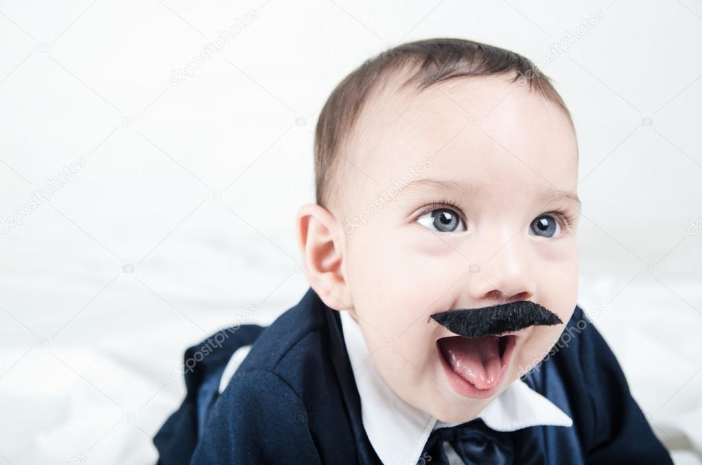 Cute beautiful baby boy in costume with mustache and suit