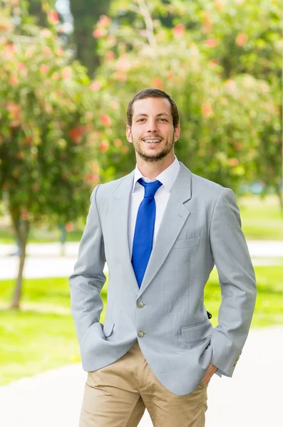 Knappe succesvolle zakenman professionele in grijs pak poseren voor de camera in het park — Stockfoto