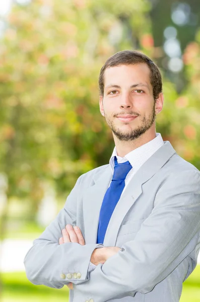 Guapo exitoso hombre de negocios profesional en traje gris posando para cámara en el parque — Foto de Stock