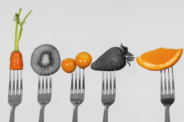 Blanco negro mezclado con foto a color de cinco tenedores que muestran zanahoria, kiwi, grosellas, fresa y pieza de naranja —  Fotos de Stock