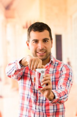 Çekici bir genç adam bir Coca Cola açma gülümseyen olabilir