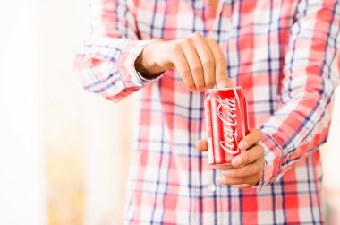 Genç adam ellerini bir Coca-Cola açılış closeup olabilir