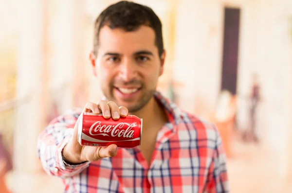 Jeune homme attrayant souriant tenant une boîte de Coca-Cola — Photo